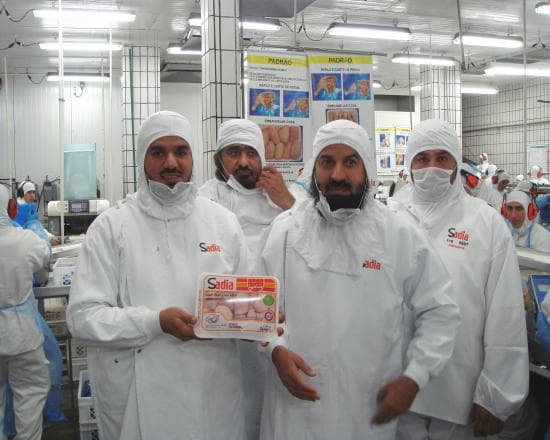 High-volume chicken processing line with quality control team
